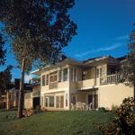 Home with porches, patio and light tan siding