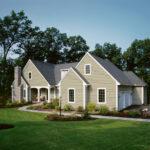 Home with manicured lawn and light green siding