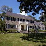 Two story home with porch and gray siding