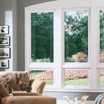 Corner windows with white trim looking out at flower bed
